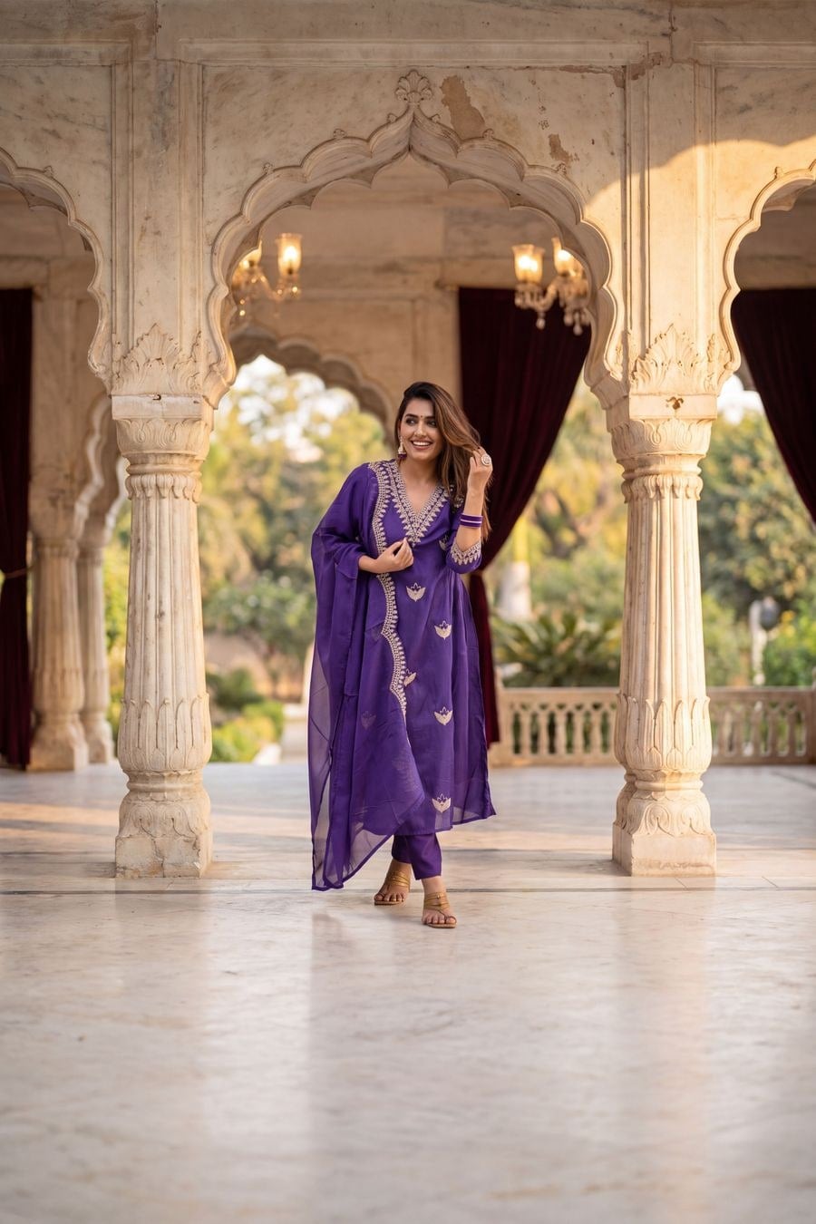 Model in a royal purple chanderi kurta set with gold embroidery and a dupatta, in a marble palace pavilion